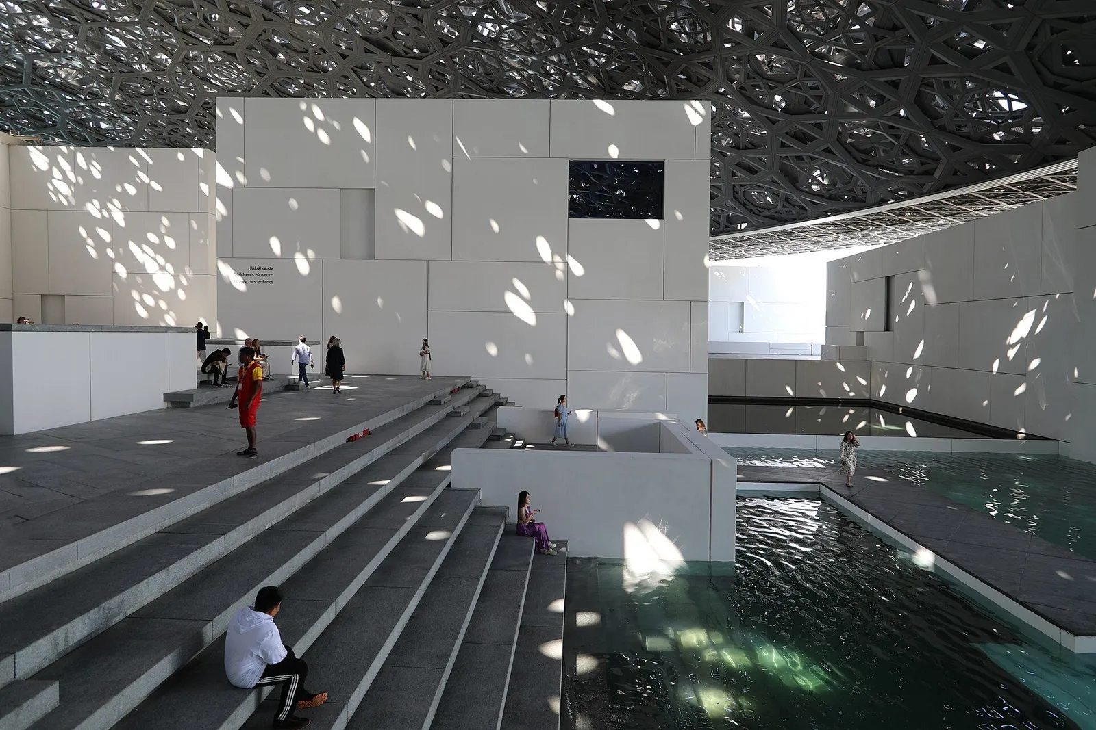 Steps and water under the Louvre Abu Dhabi’s latticed dome