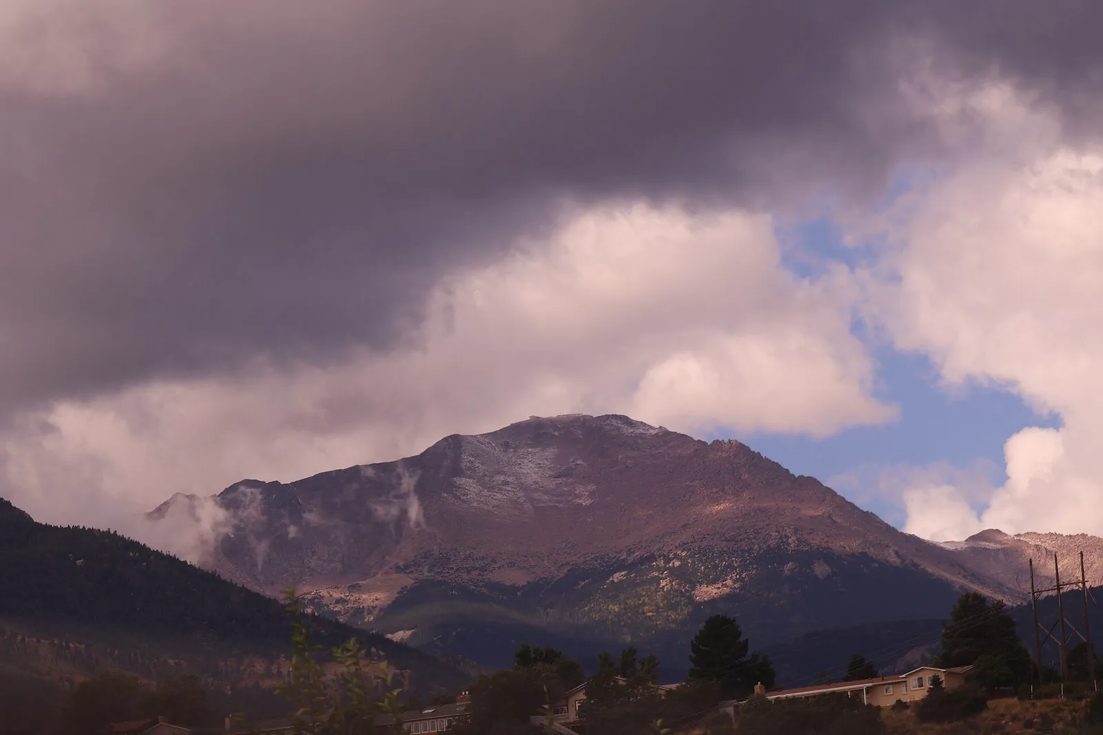 Pikes Peak under a cloudy sky, forest in the foreground