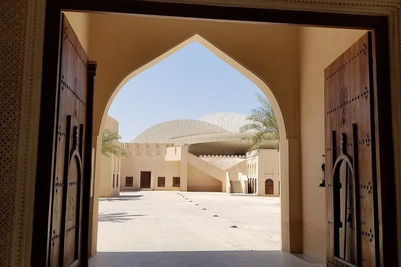 The National Museum of Qatar’s courtyard through a carved doorway