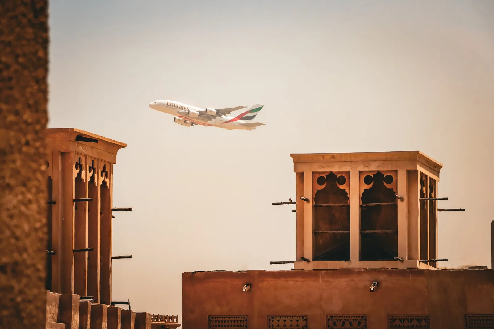Al Fahidi’s wind towers with a plane passing overhead