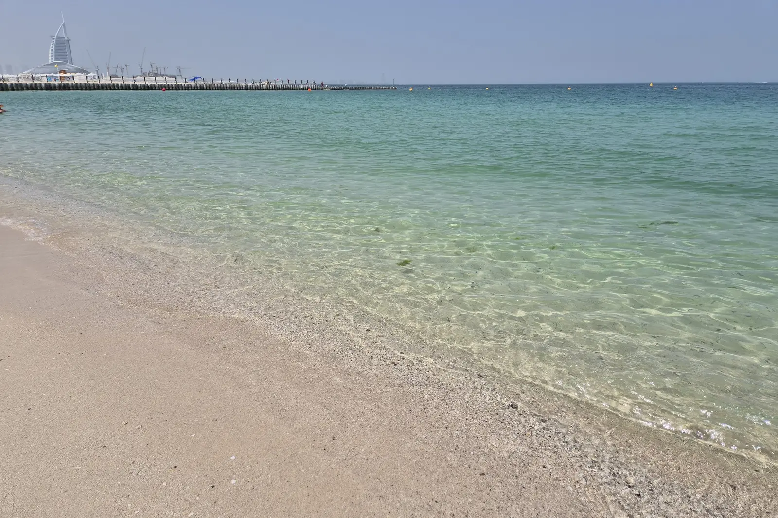 The pale sand and shallow water of Kite Beach, the Burj Al Arab on the horizon