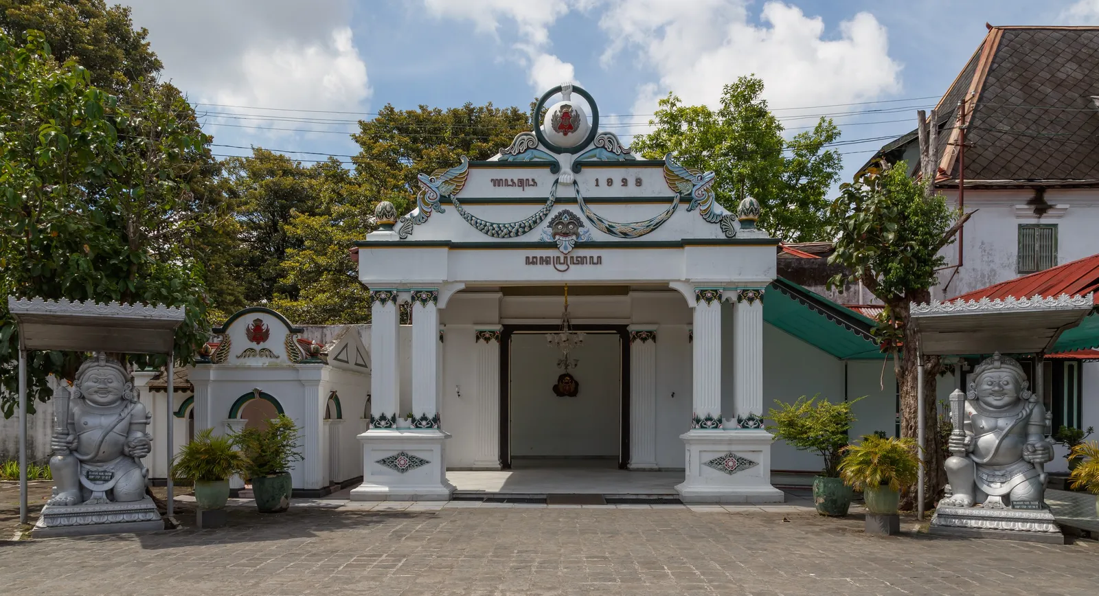 A white gate of the Kraton in Yogyakarta, flanked by 2 guardian statues