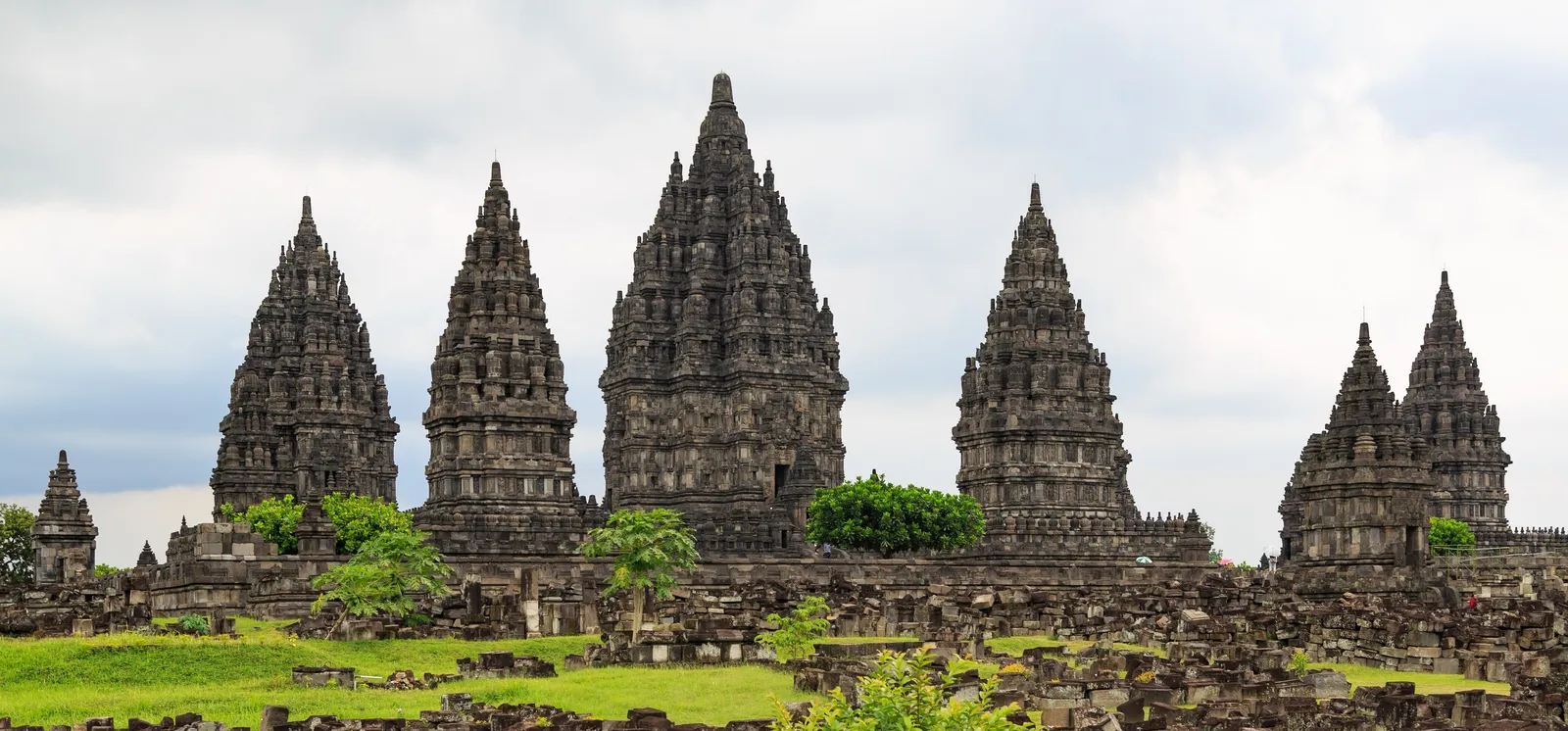 The spires of Prambanan above a field of fallen stones