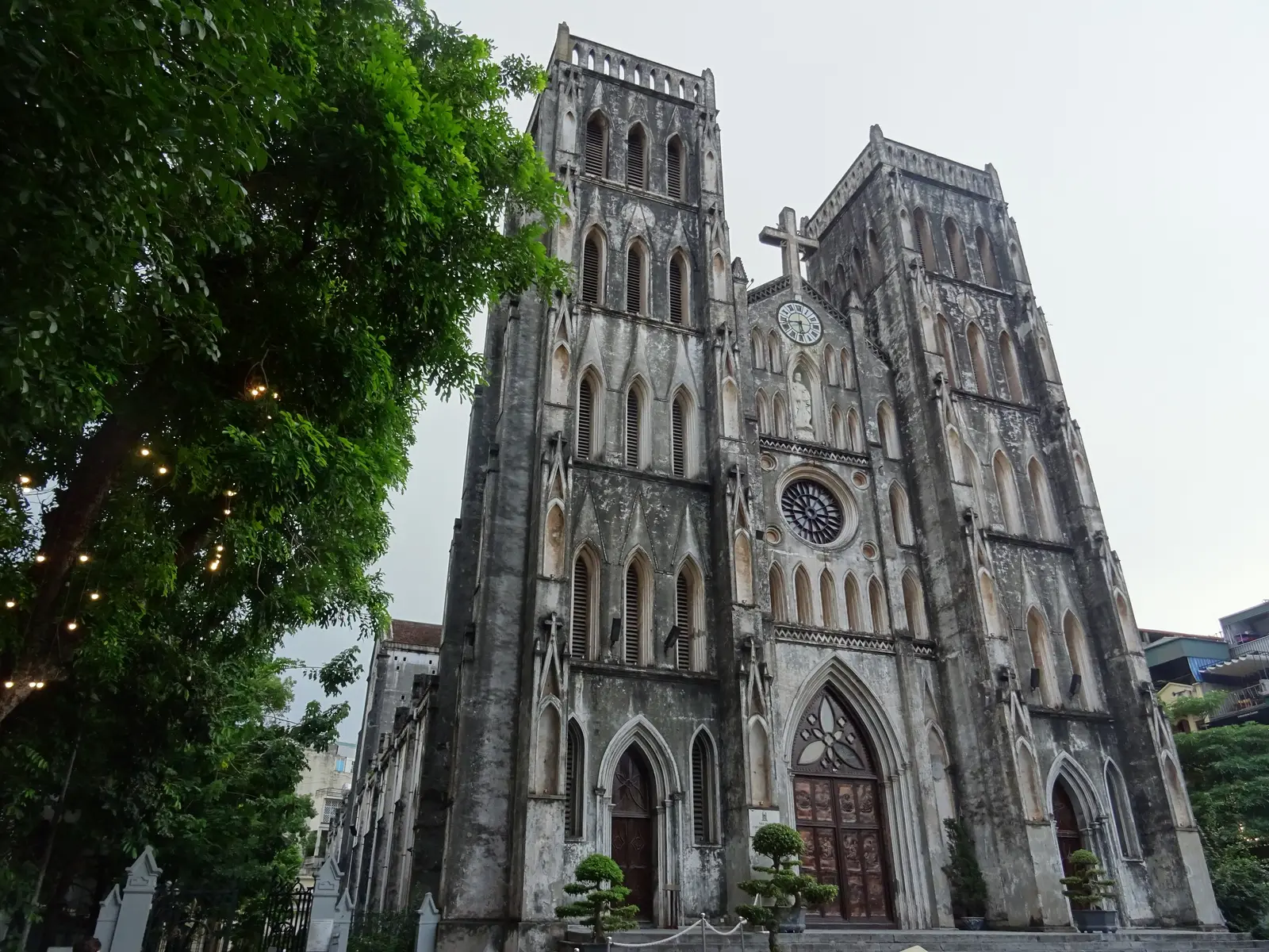The 2 grey neo-Gothic towers of St Joseph’s Cathedral, trees to the left