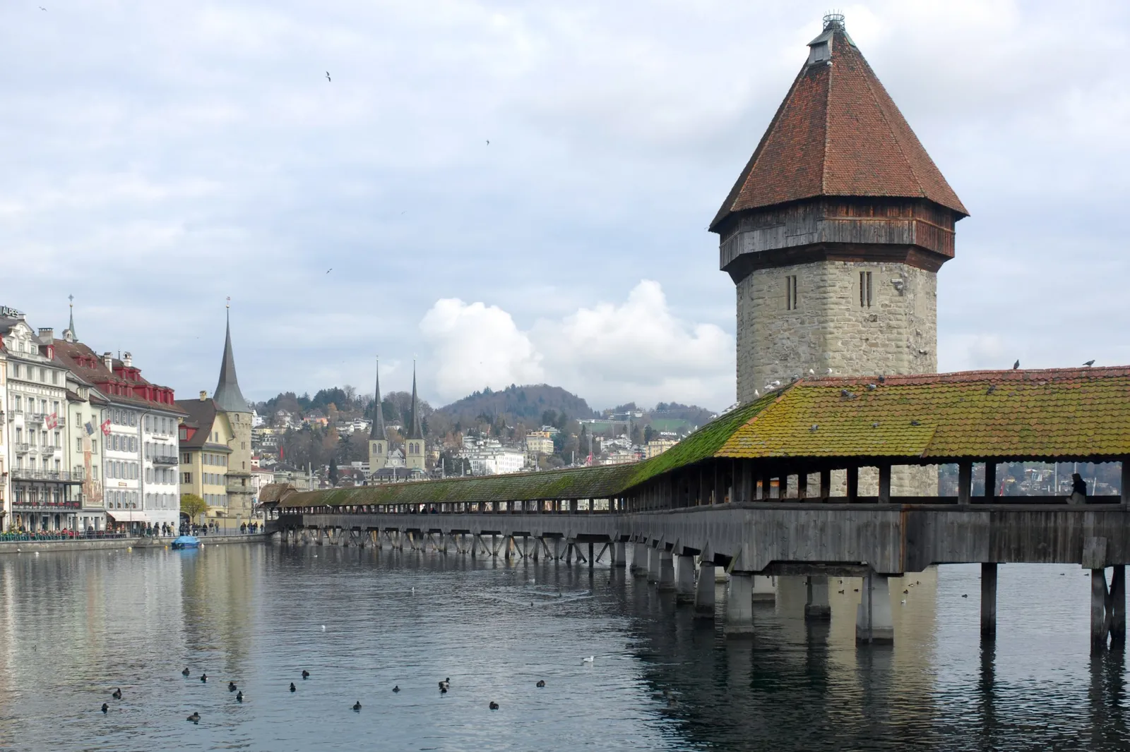 Lucerne’s Kapellbrücke, the covered wooden bridge, and its octagonal Water Tower on the Reuss, with the old town behind