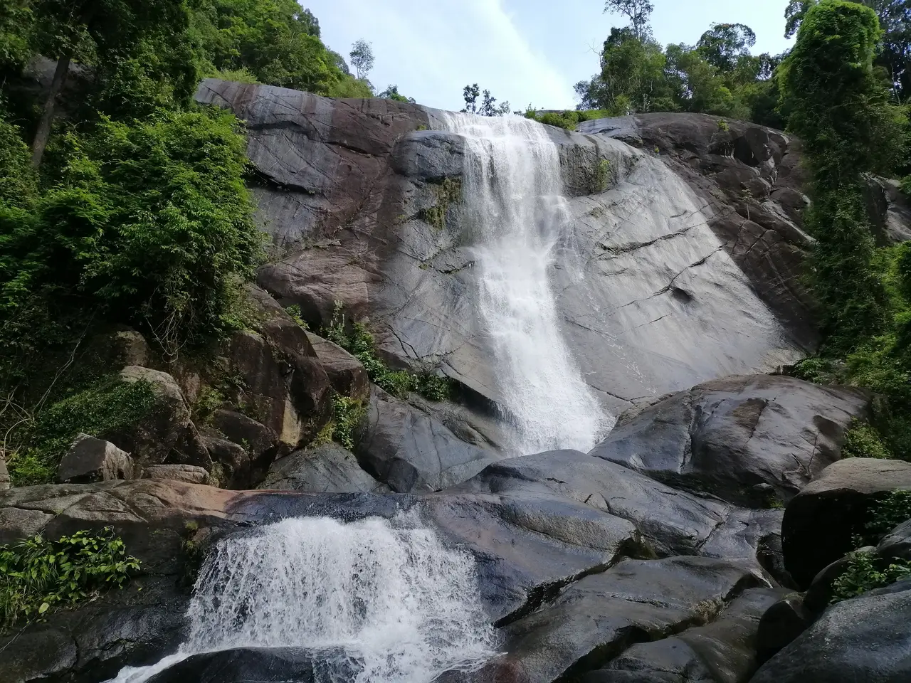 The Telaga Tujuh falls sliding down granite slabs between trees