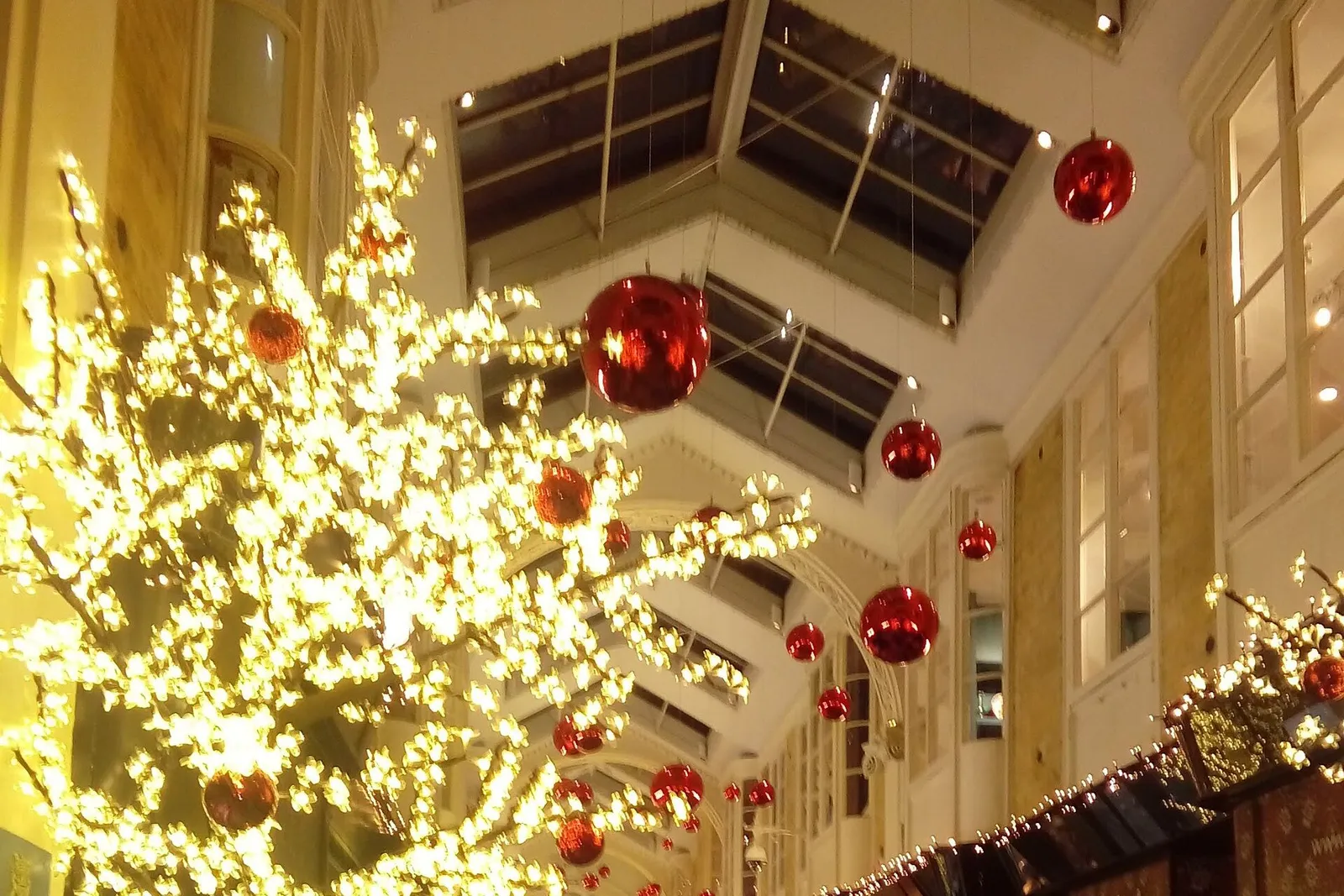 The Burlington Arcade with Christmas lights and red baubles beneath its glass roof
