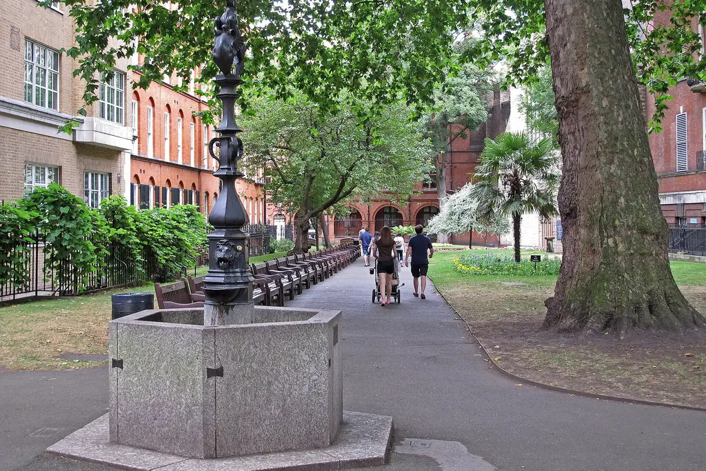 The path through Mount Street Gardens with the stone drinking fountain, benches and plane trees