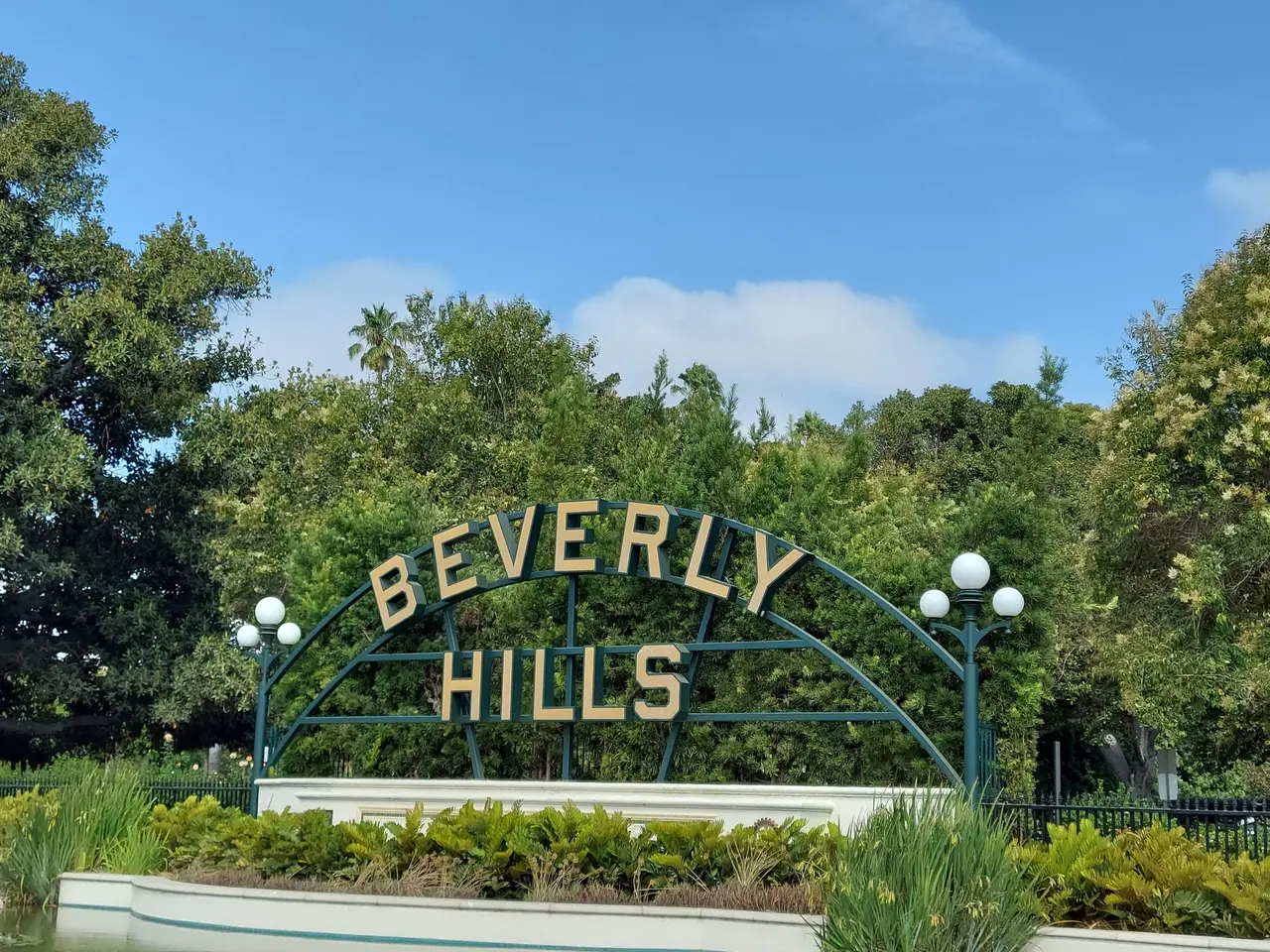 The Beverly Hills sign in Beverly Gardens Park, among hedges and trees