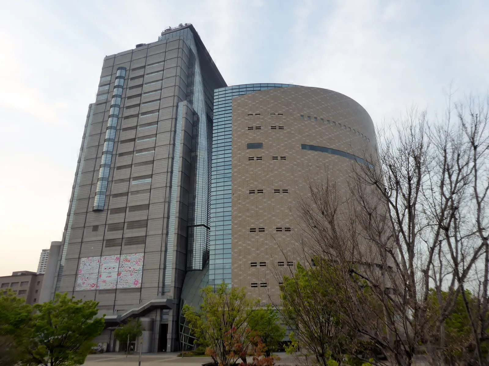 The curved façade of the Osaka Museum of History beside the tall NHK Osaka building
