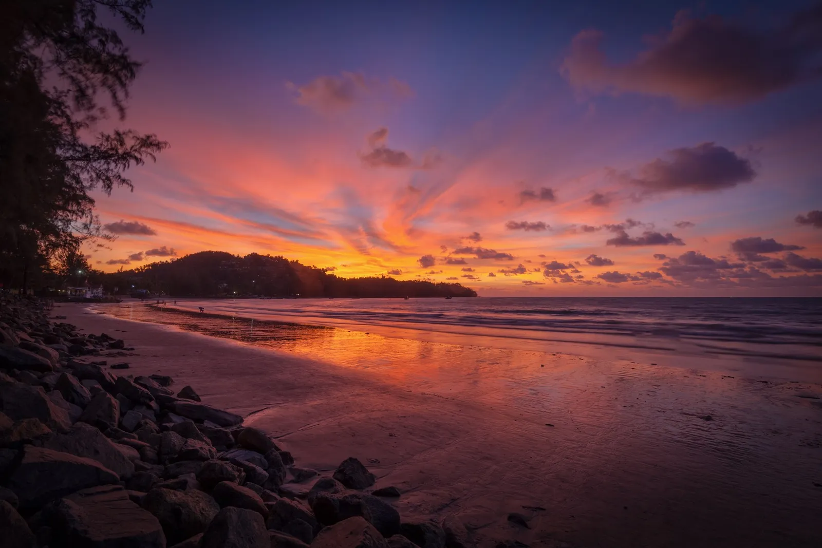 Sunset over Bang Tao Beach, the sky orange and violet above the headland