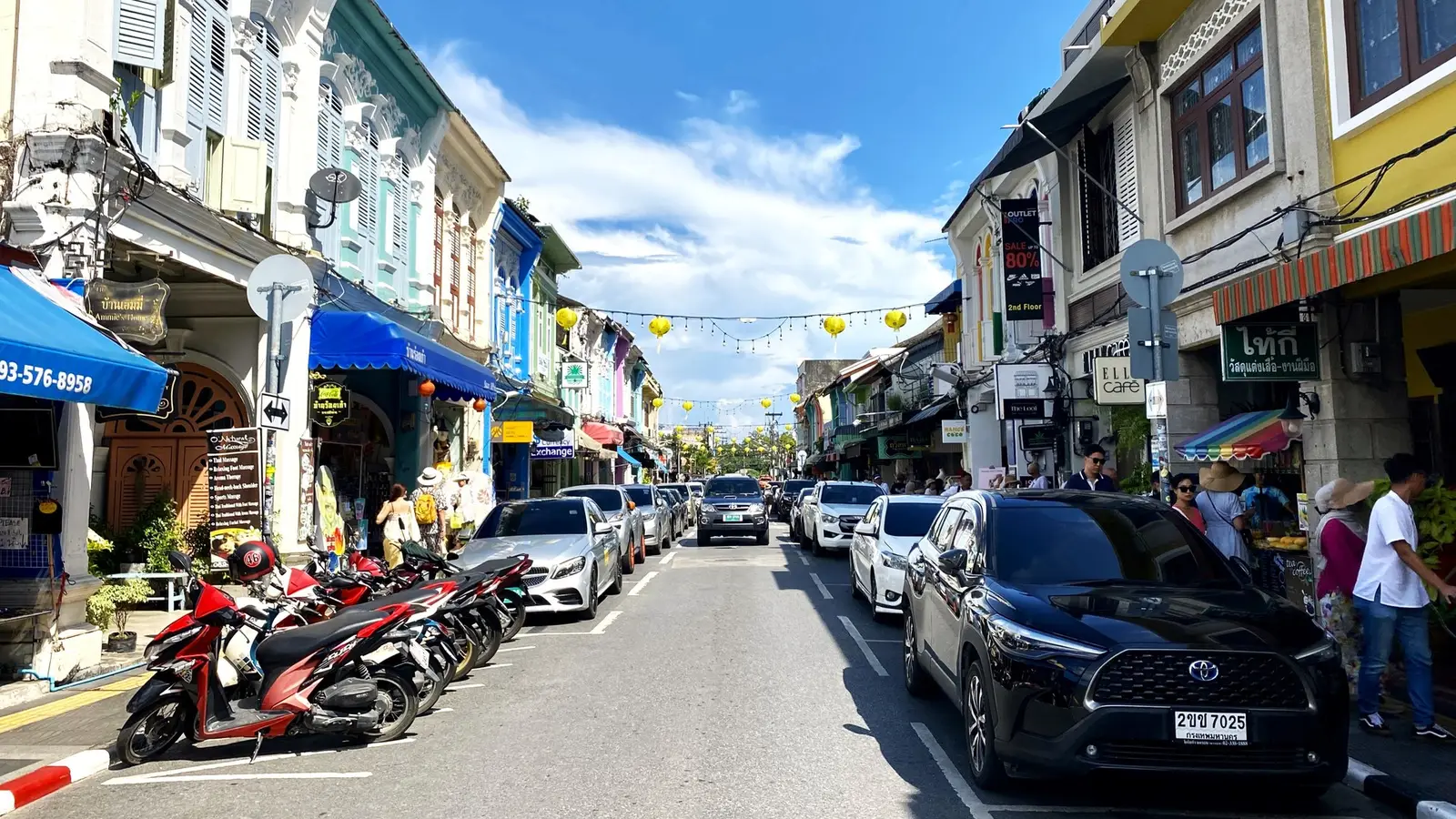 Thalang Road in Phuket Old Town: pastel shophouses, motorbikes and parked cars