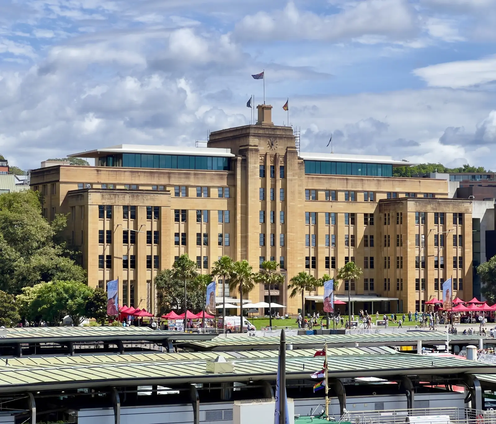 The tall sandstone-coloured façade of the Museum of Contemporary Art behind the ferry wharves