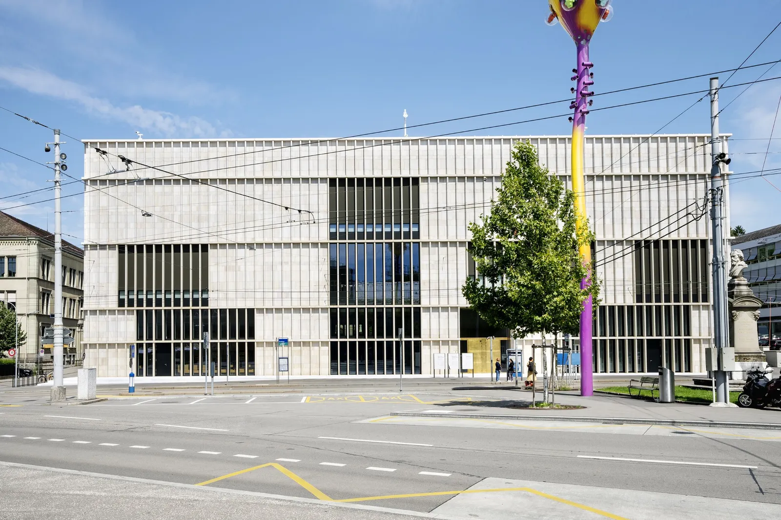 The Kunsthaus’s Chipperfield building on Heimplatz: a pale stone façade with tall narrow openings and a purple sculpture beside it