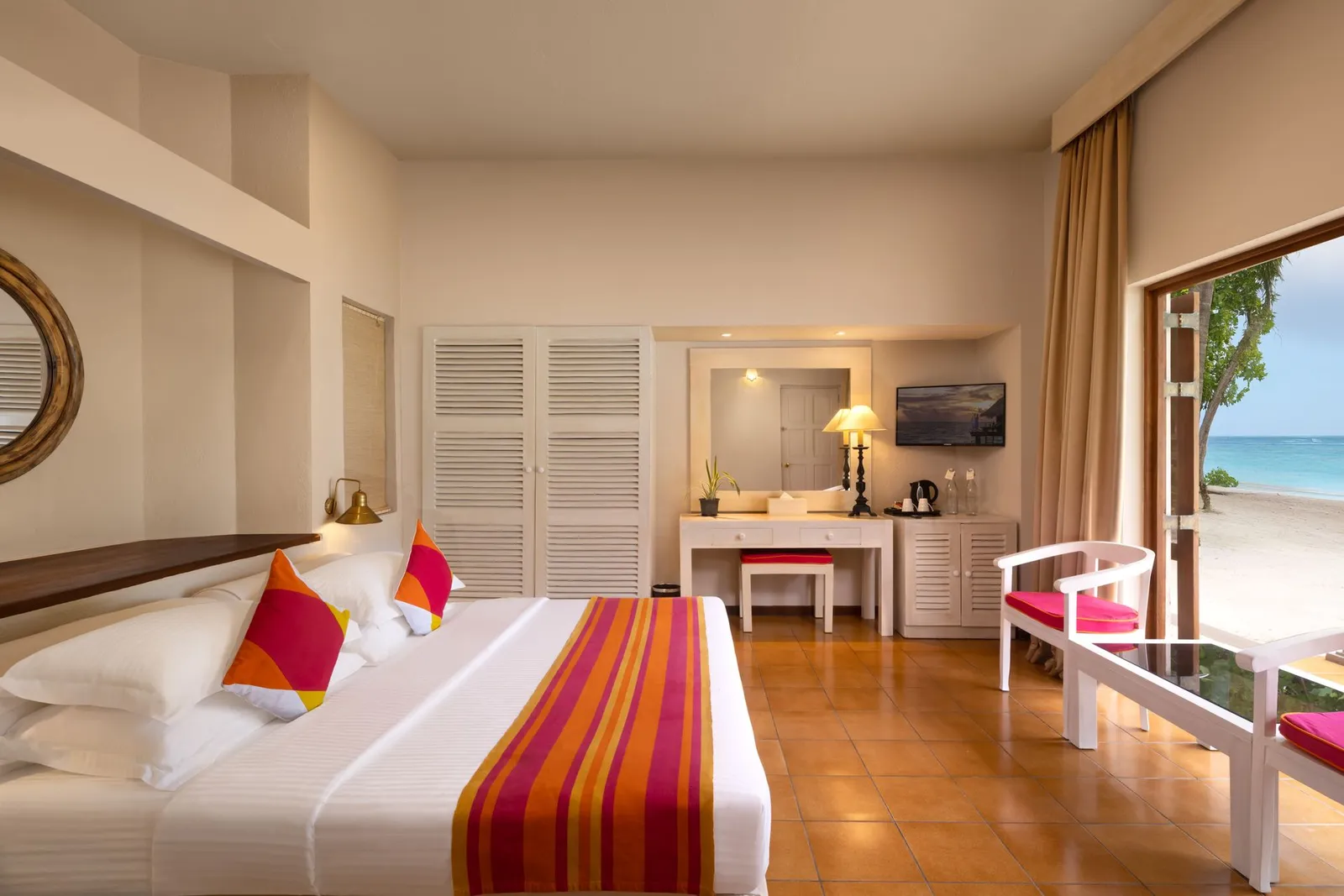 A Classic Beach View room: the bed, the wooden floor and the door open on to the beach