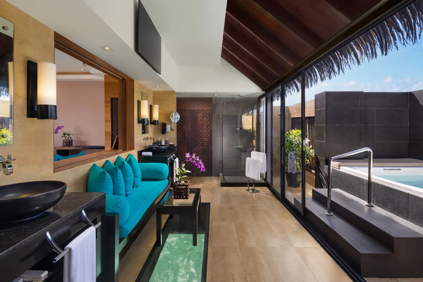 A villa bathroom: the sofa, the glass floor panel and the Jacuzzi on the terrace