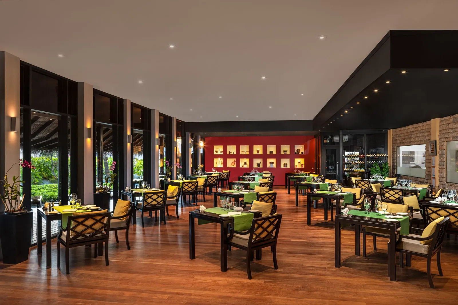 Farivalhu’s dining room, tables laid in green and the red wall
