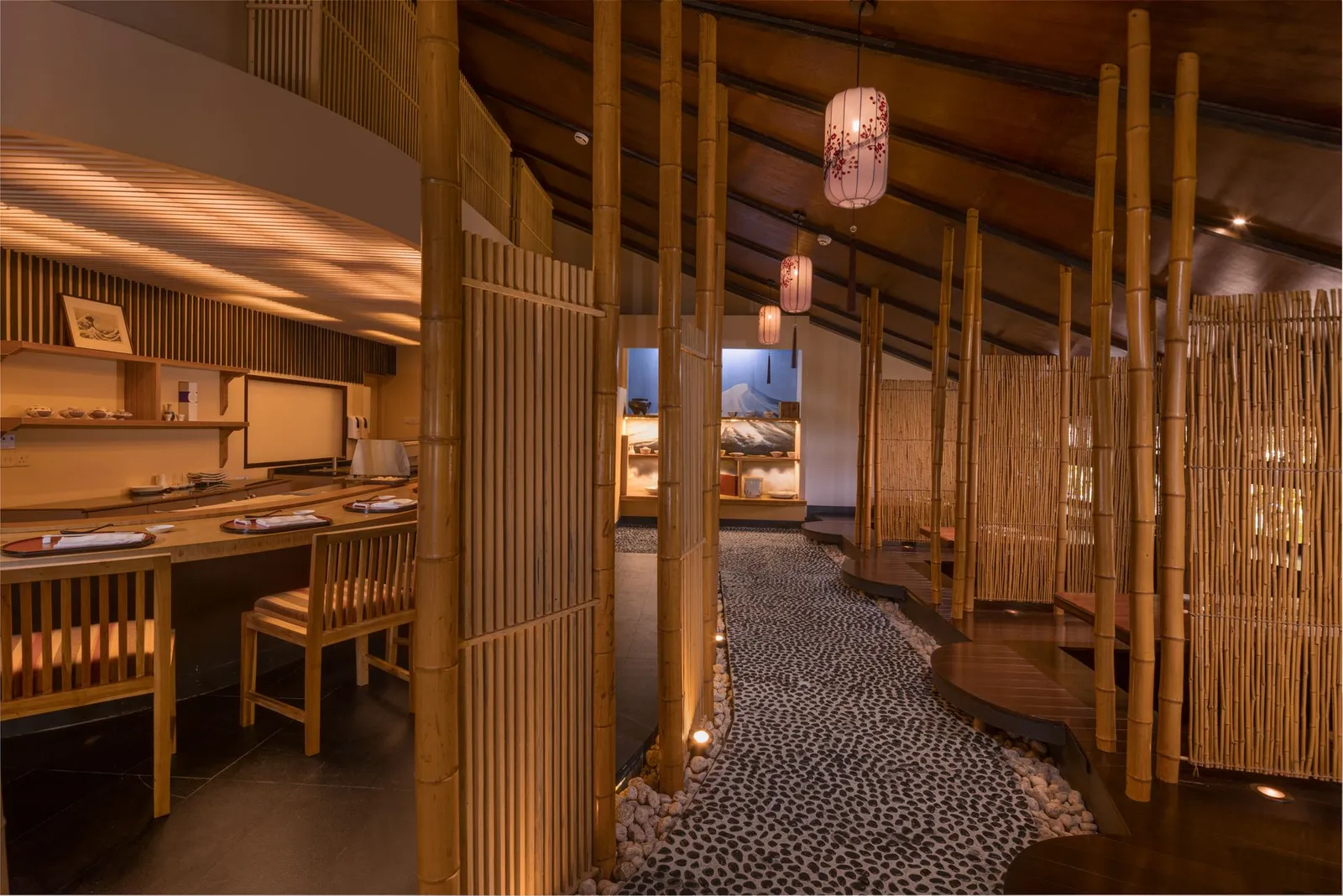 Inside Kithajima: wood, bamboo canes and a pebble path between the tables
