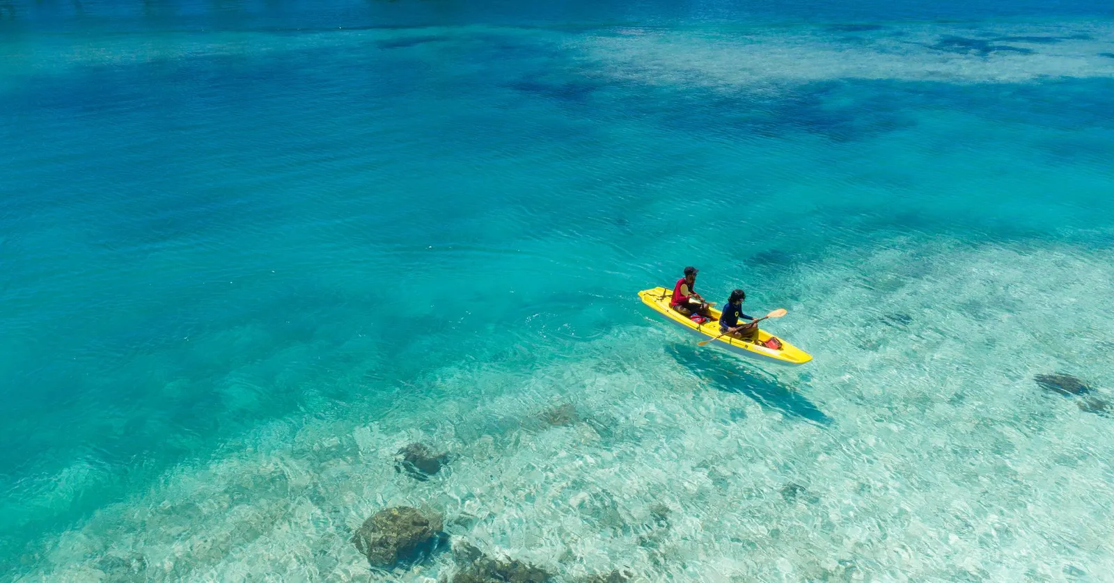 2 people in a canoe on the clear lagoon