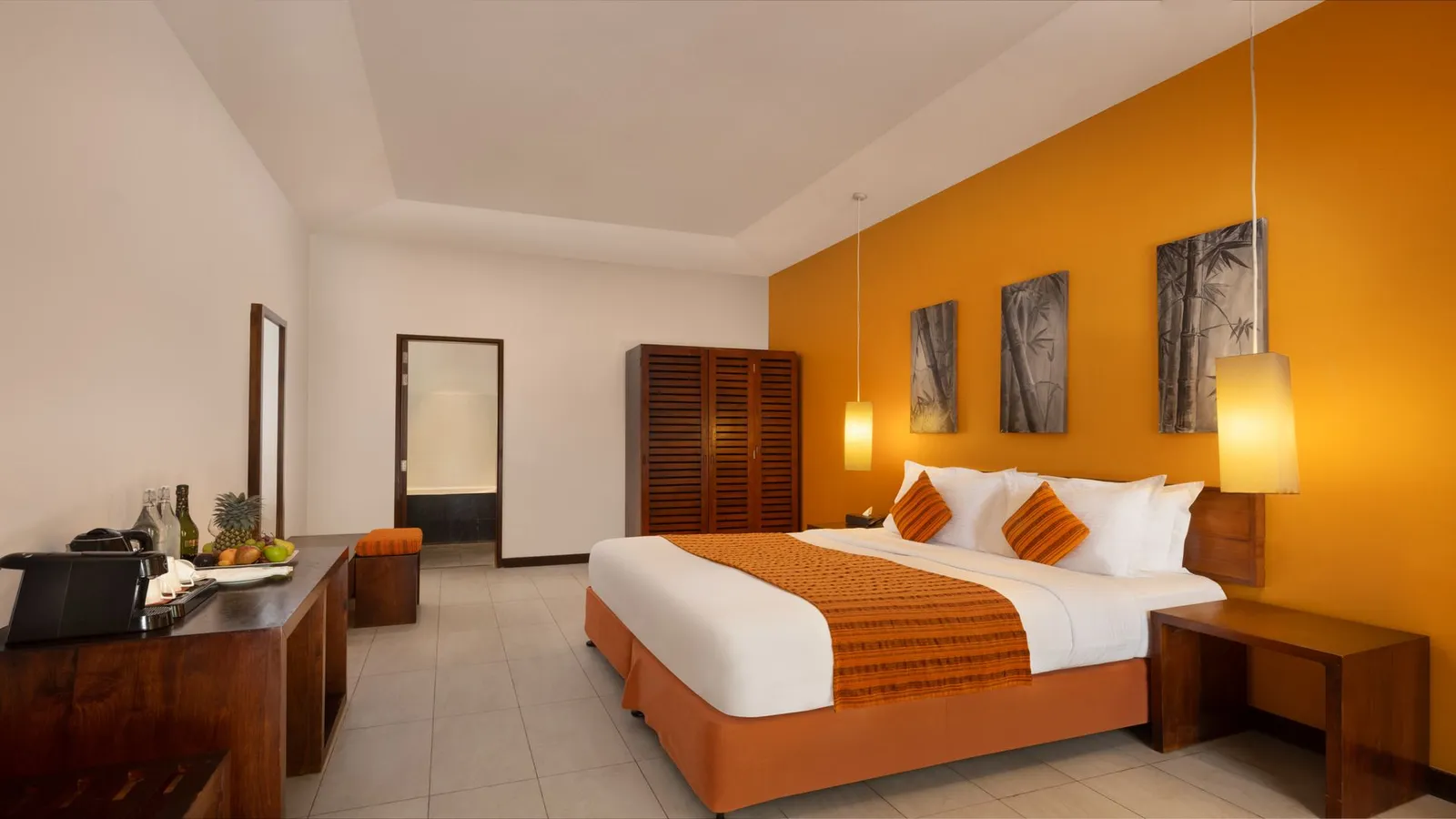 A Lohis Villa bedroom, the bed and pictures on an orange wall
