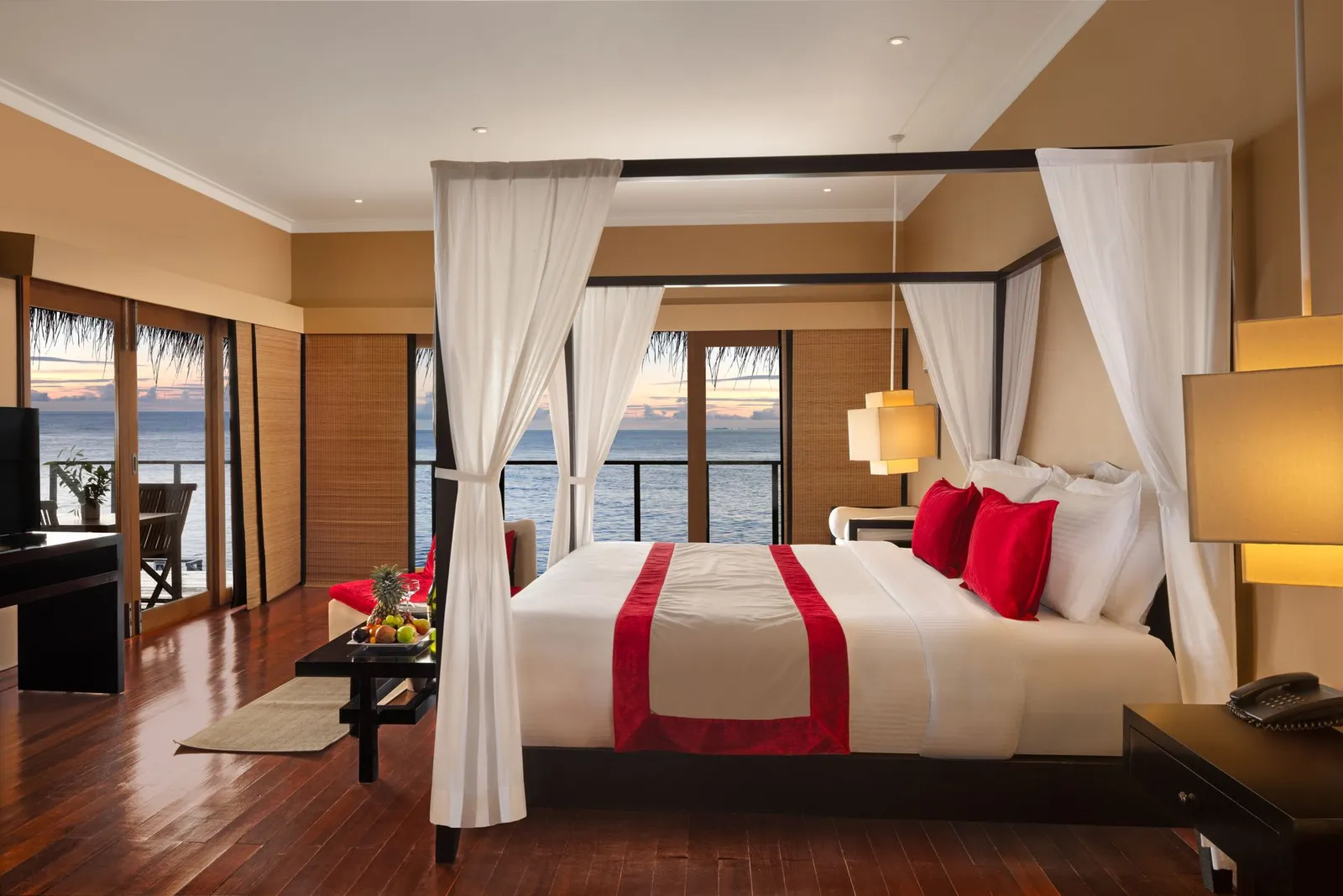 A Sunrise Ocean Villa: the canopy bed and the glass doors to the ocean