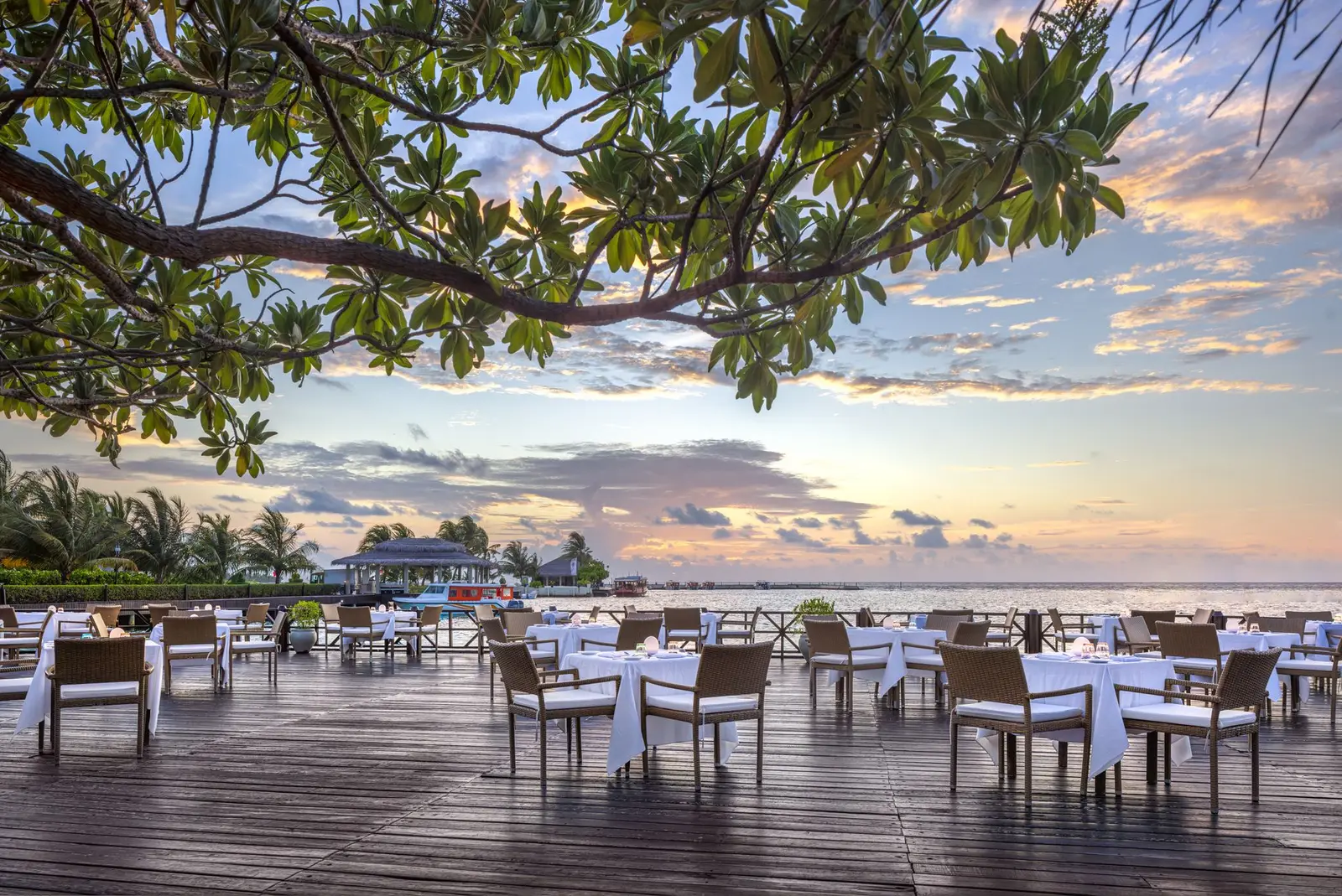 The Sunset Restaurant’s deck over the water at sunset, the tables laid