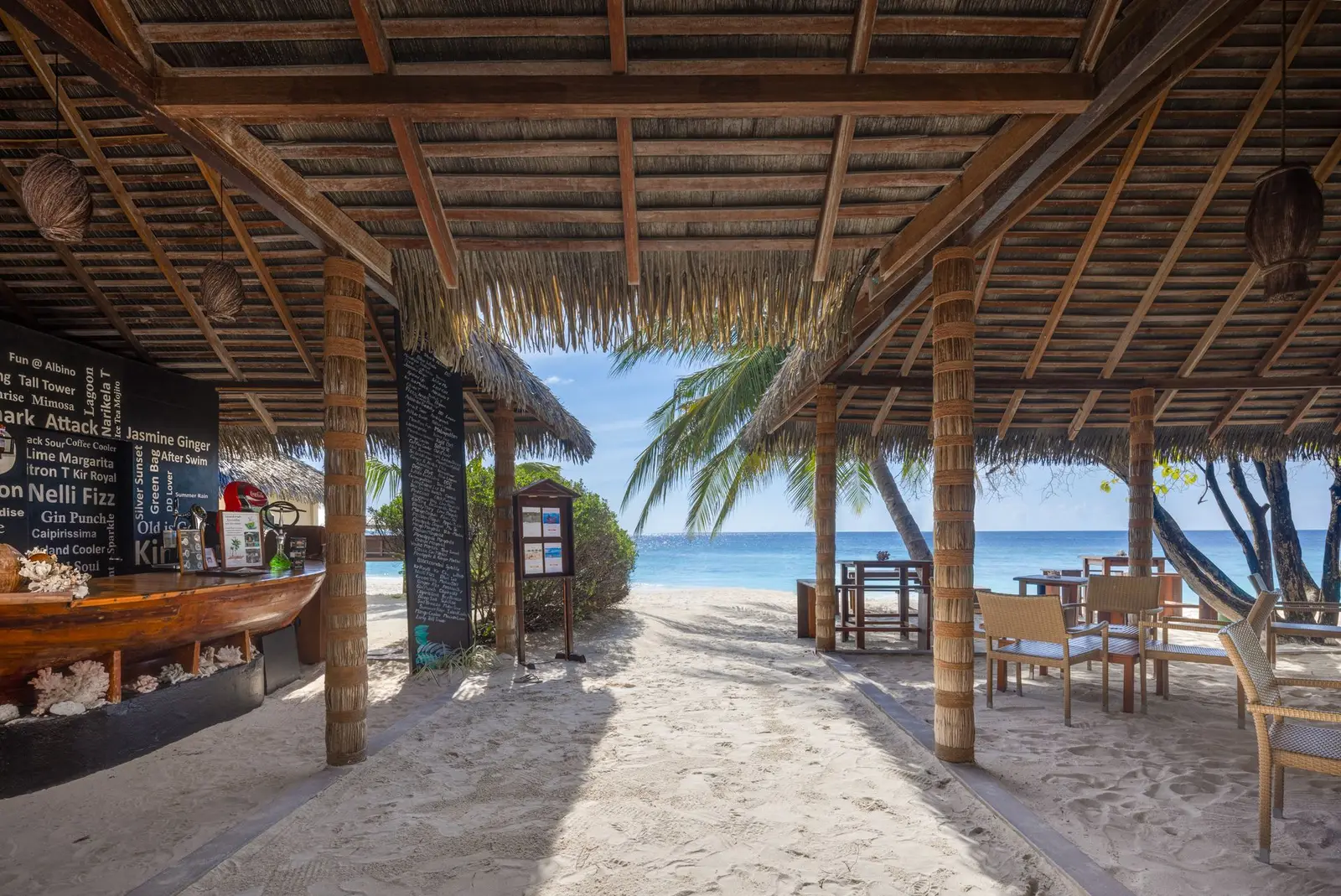 The Albino Bar under its thatched roof, sand underfoot and the beach in front