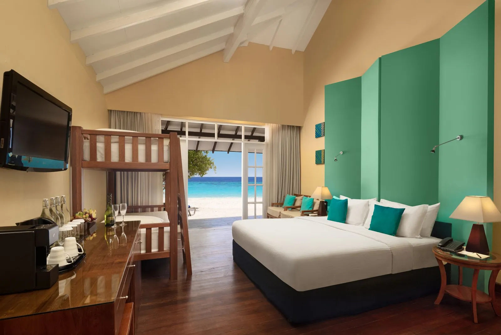 A Family Beach Villa: the double bed, green walls and door towards the beach