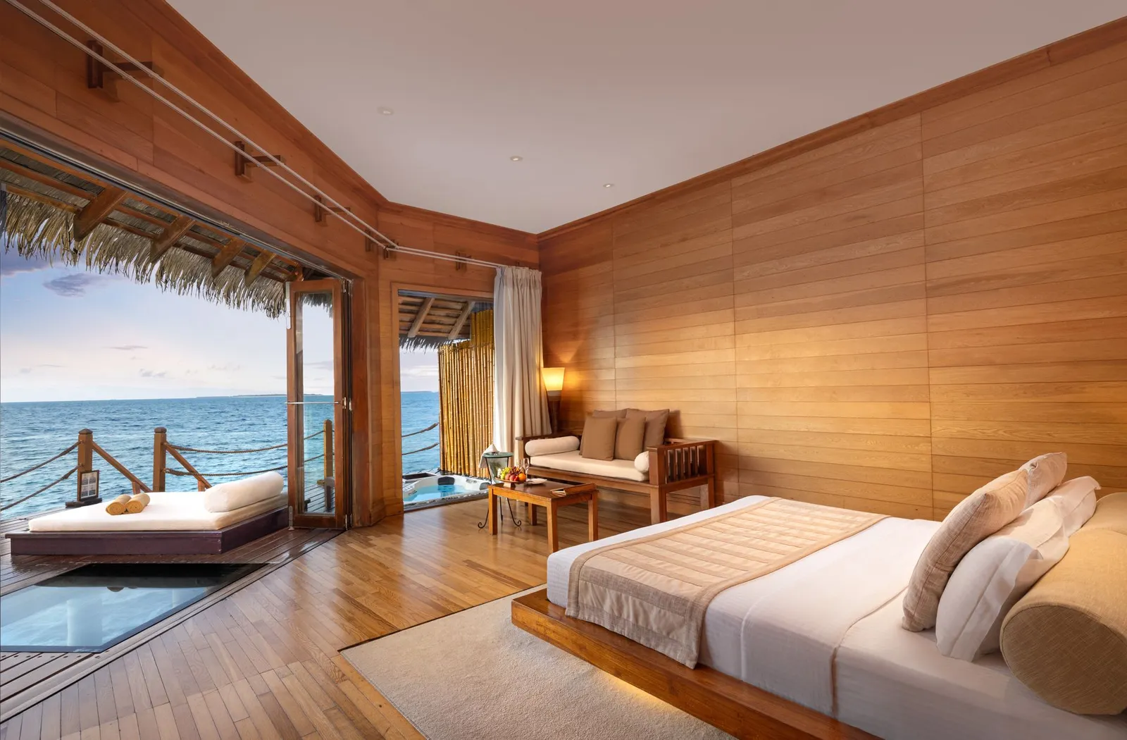 A Prestige Water Villa: the bed, the timber walls and the deck over the water