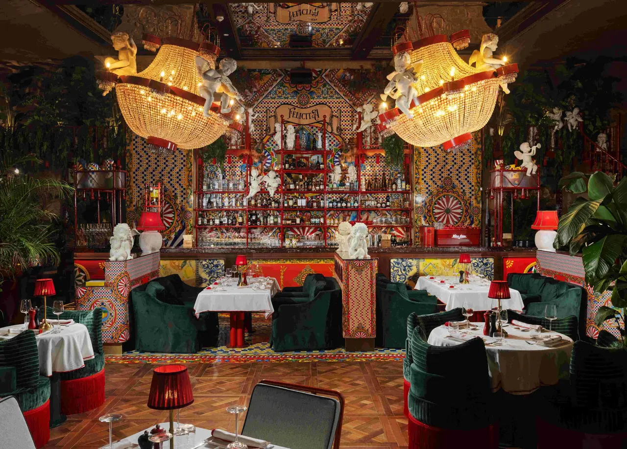 Felicità’s dining room with red lampshades and green velvet chairs