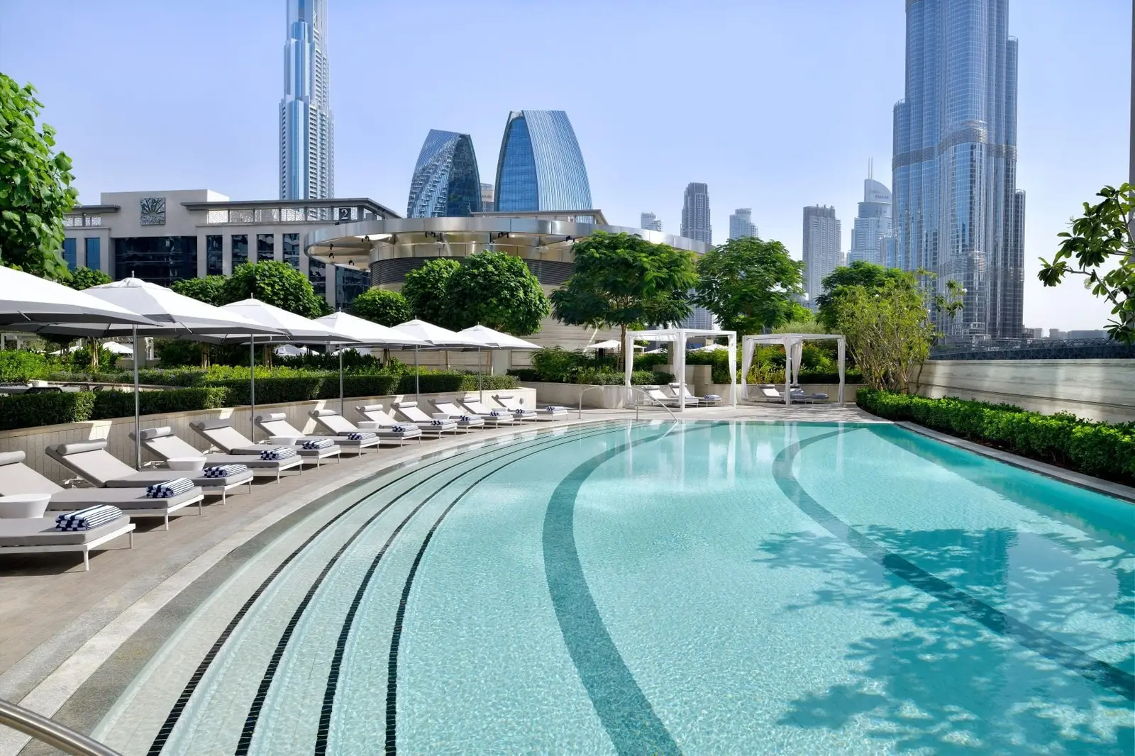 The ground-floor pool with white loungers and the Burj Khalifa beyond
