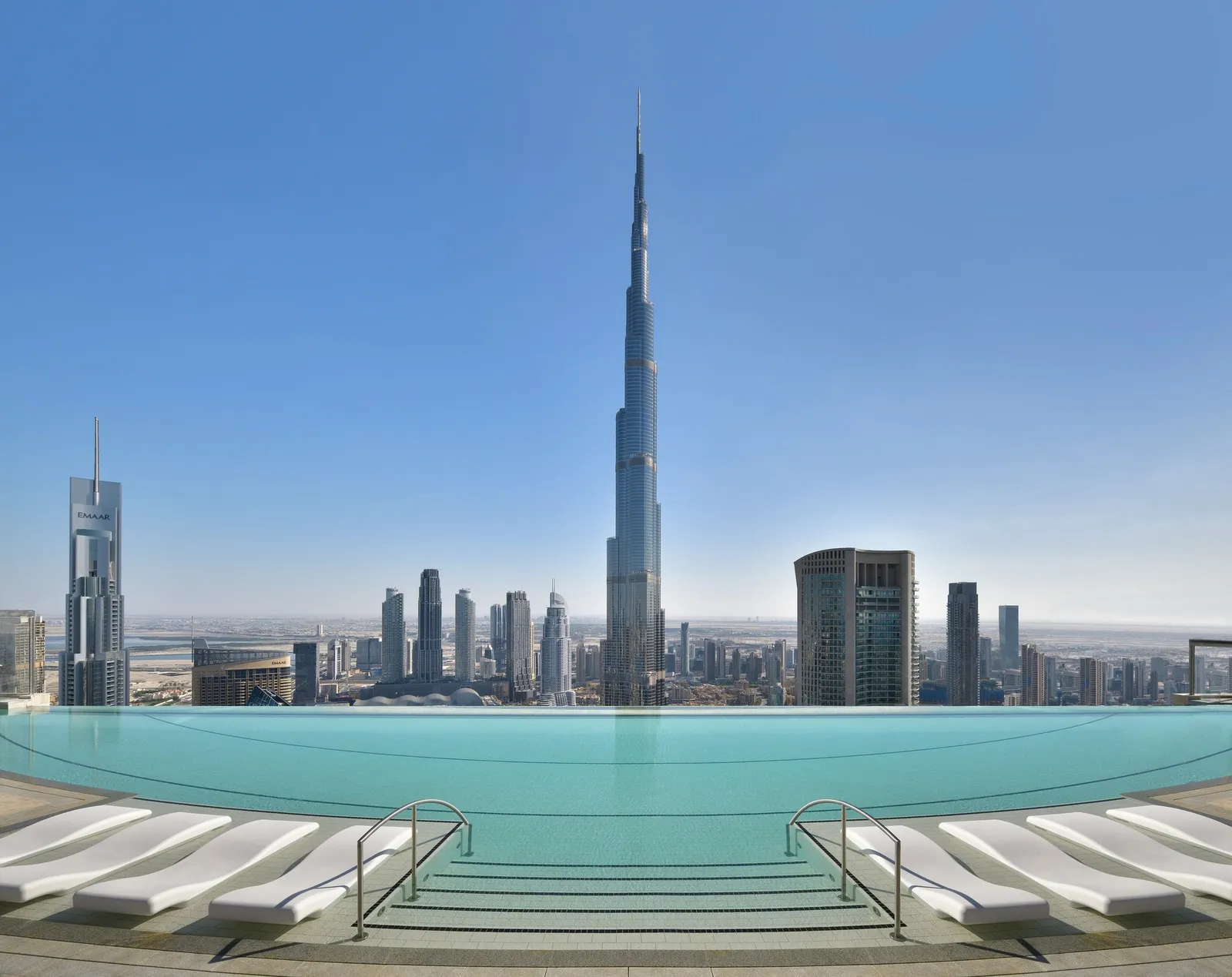 The 54th-floor infinity pool by day, with loungers and the Burj Khalifa