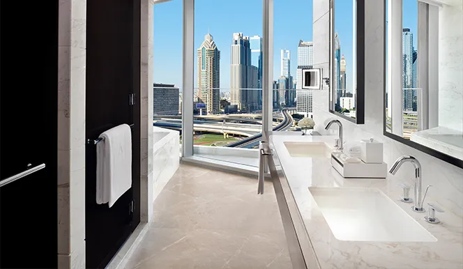 The marble bathroom with 2 basins in front of the glass wall onto the city