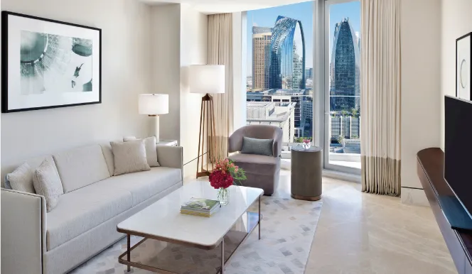 An Executive Suite living room with a pale sofa and glass walls