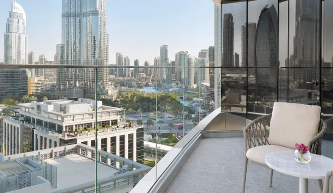 A balcony with a round table and the Burj Khalifa above Downtown