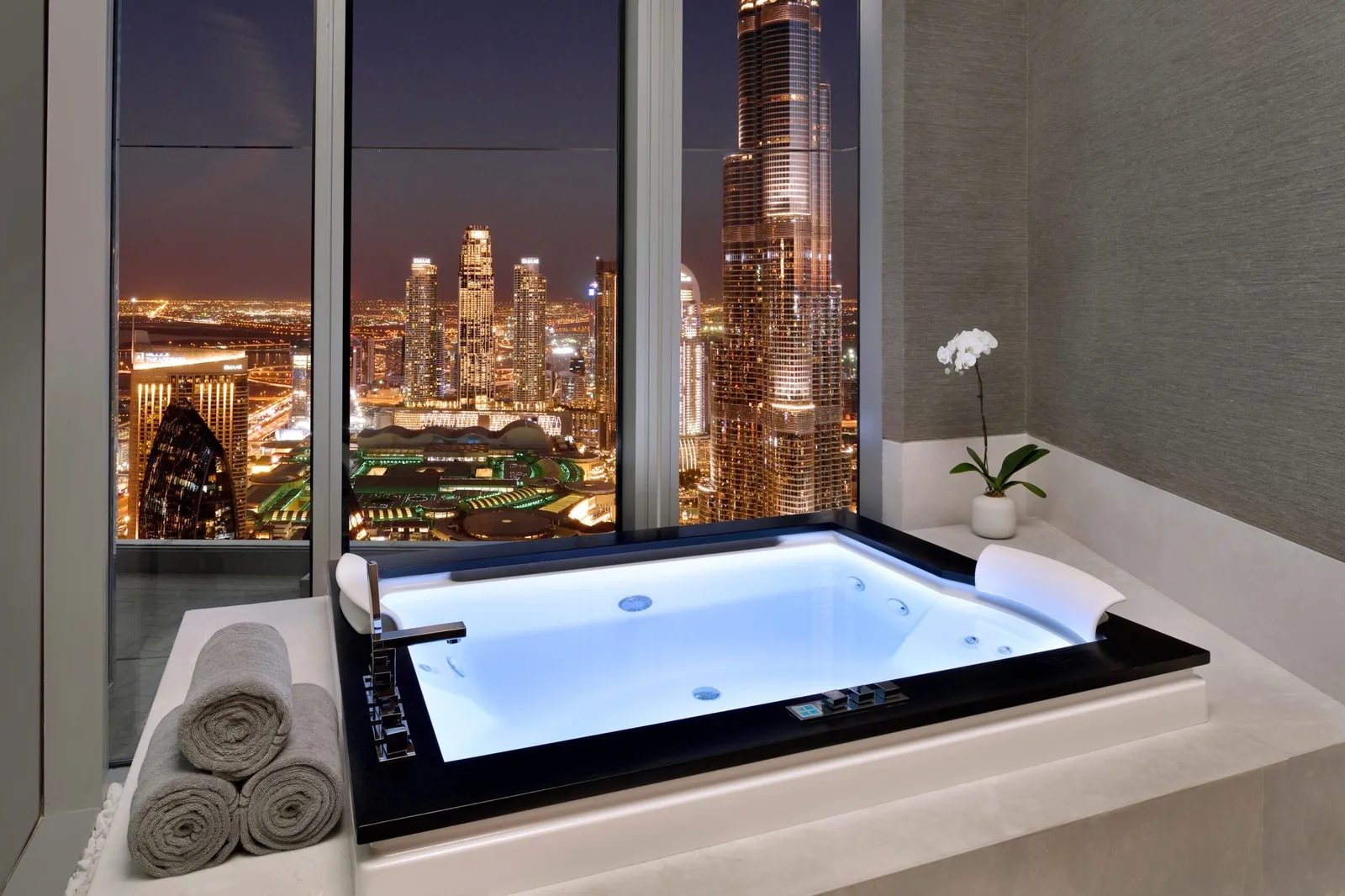 A spa suite whirlpool facing the lit Burj Khalifa