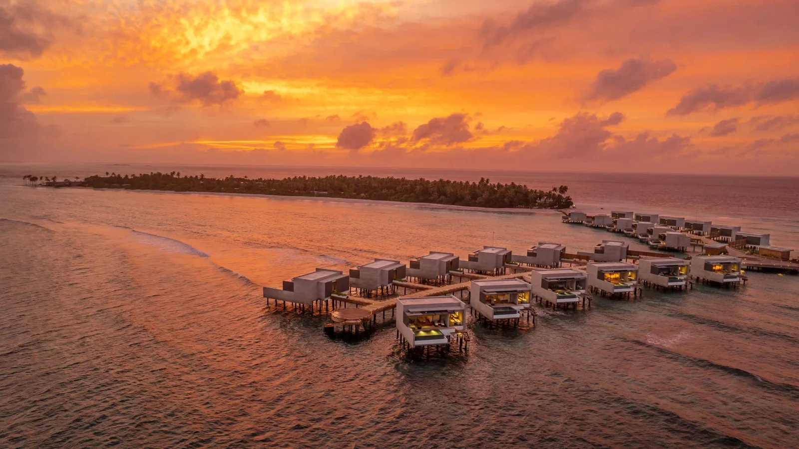 The water villas and island at sunset.
