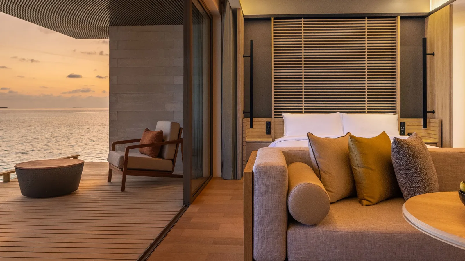The overwater villa sofa and terrace at sunset.