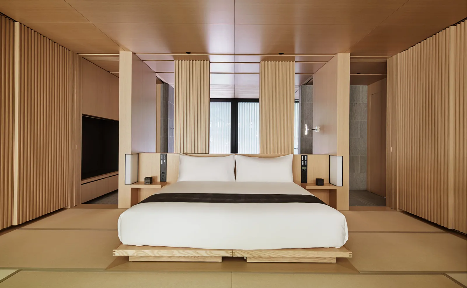 A Kaede room: the low bed on tatami between pale slatted timber walls and a tall window.