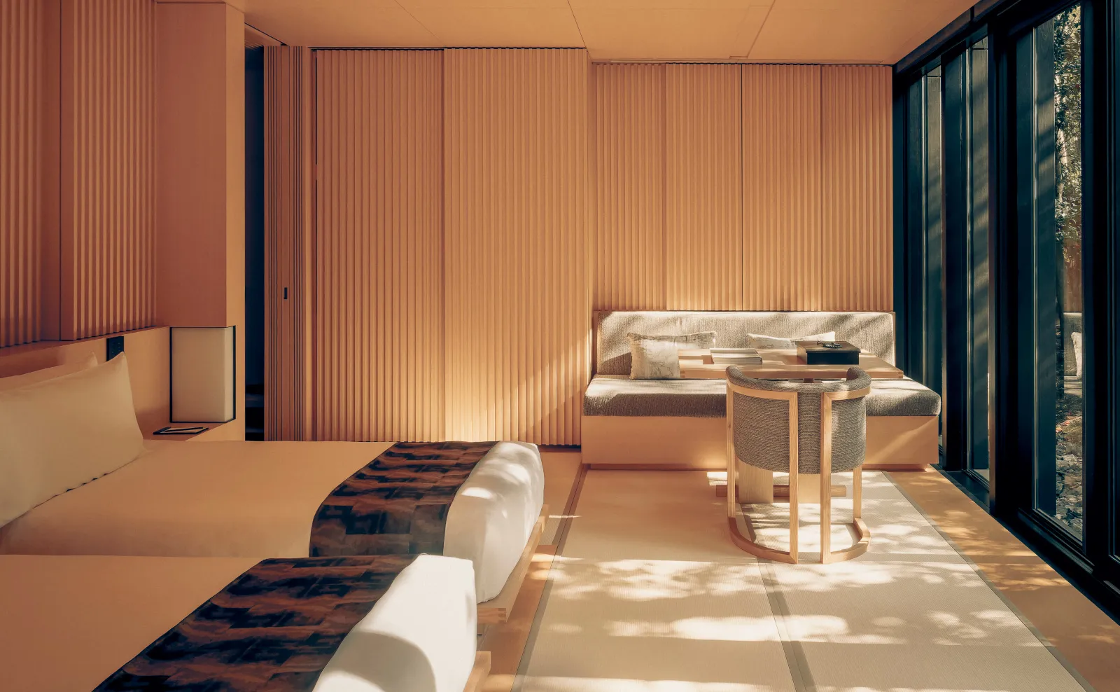 A Nara room with twin beds on tatami, the window seat and garden light coming through the glass.