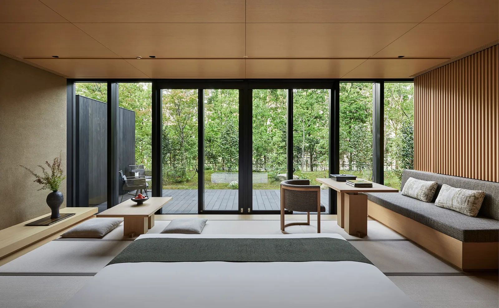 A Susuki Terrace room: tatami, a low table, a long sofa and the glass wall open onto the terrace and the garden.