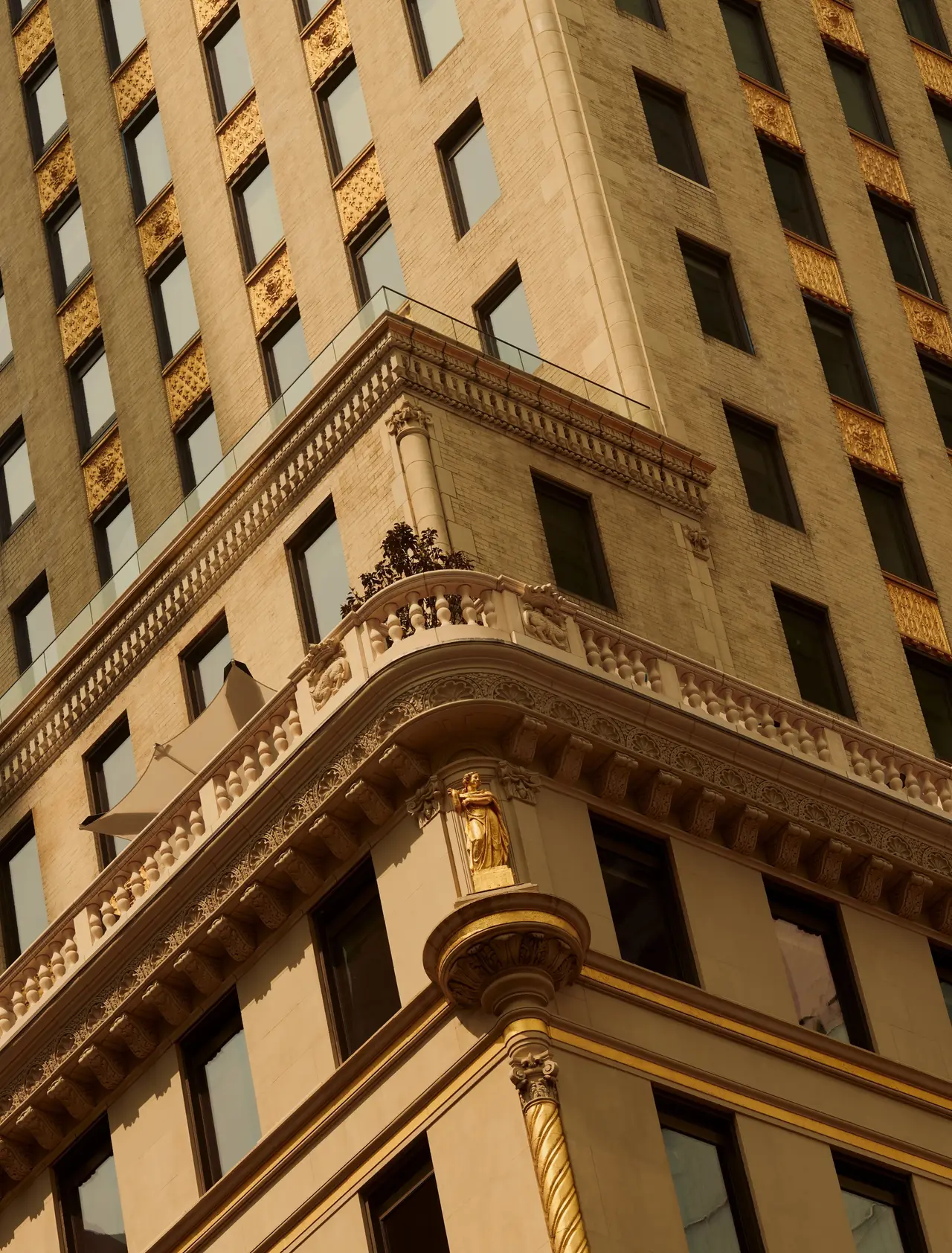 The Crown Building’s stone façade seen from below, with decorated windows and gilded details