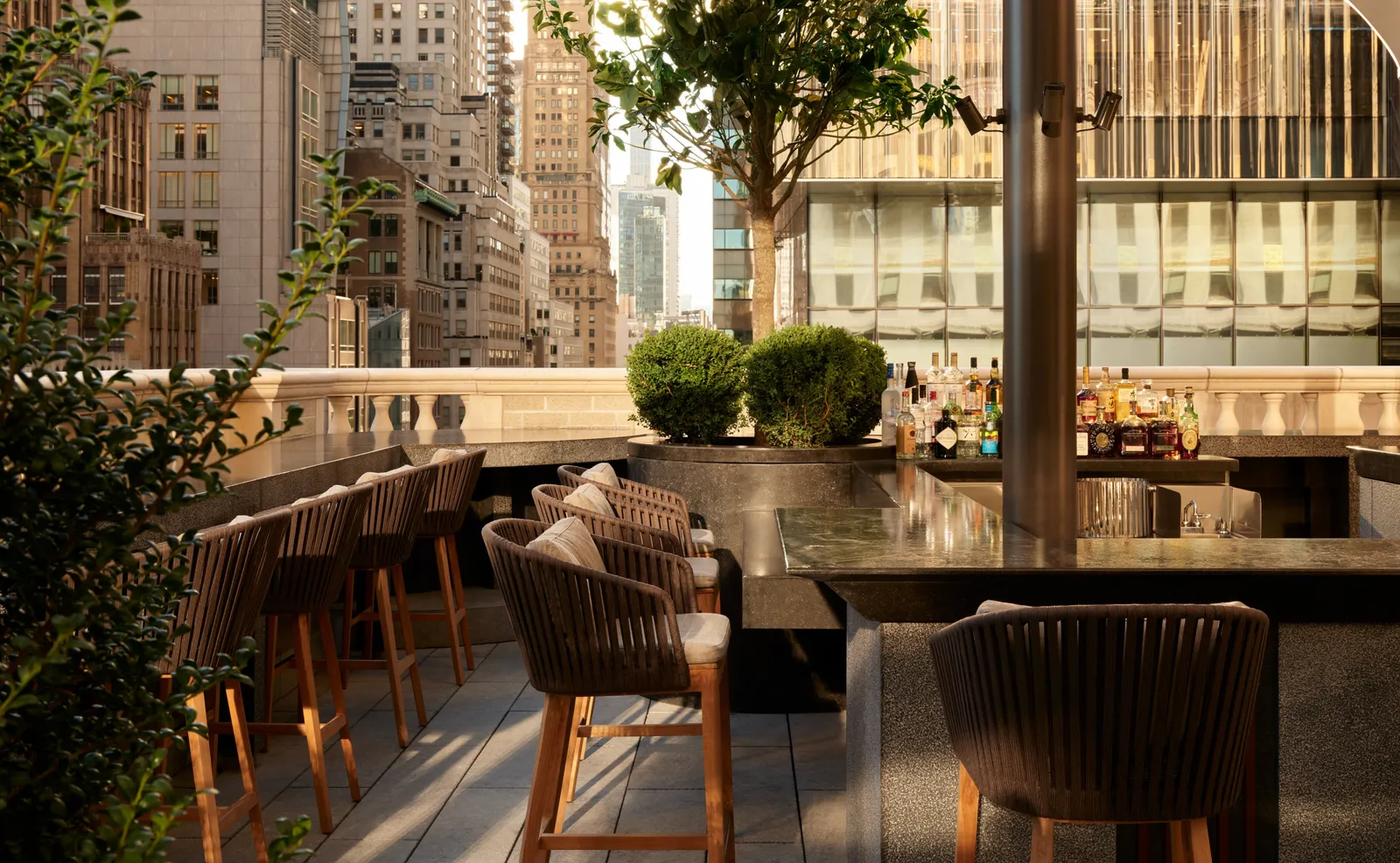 The Garden Terrace bar with timber chairs, planting and Midtown buildings beyond