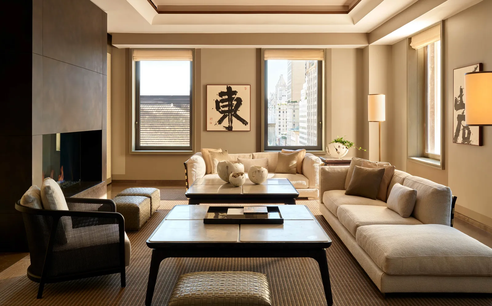 Aman Suite at Aman New York with floor-to-ceiling windows, neutral furnishings, and minimalist décor overlooking the city.