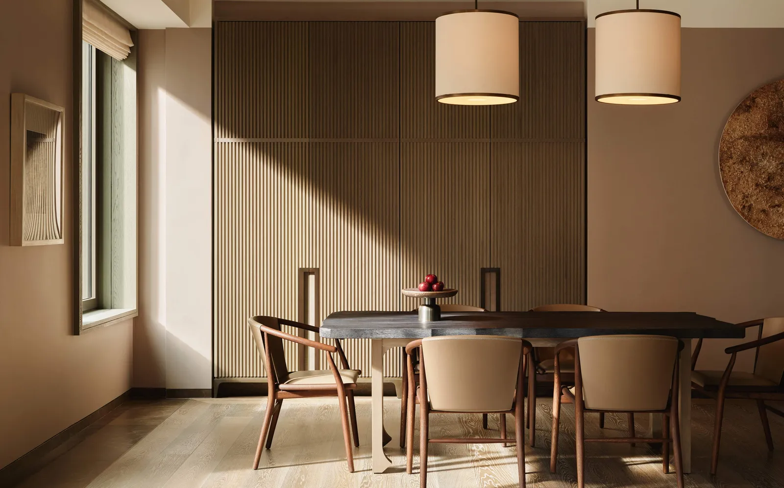 Corner suite dining area at Aman New York, with natural light, wooden table, and mid-century chairs.