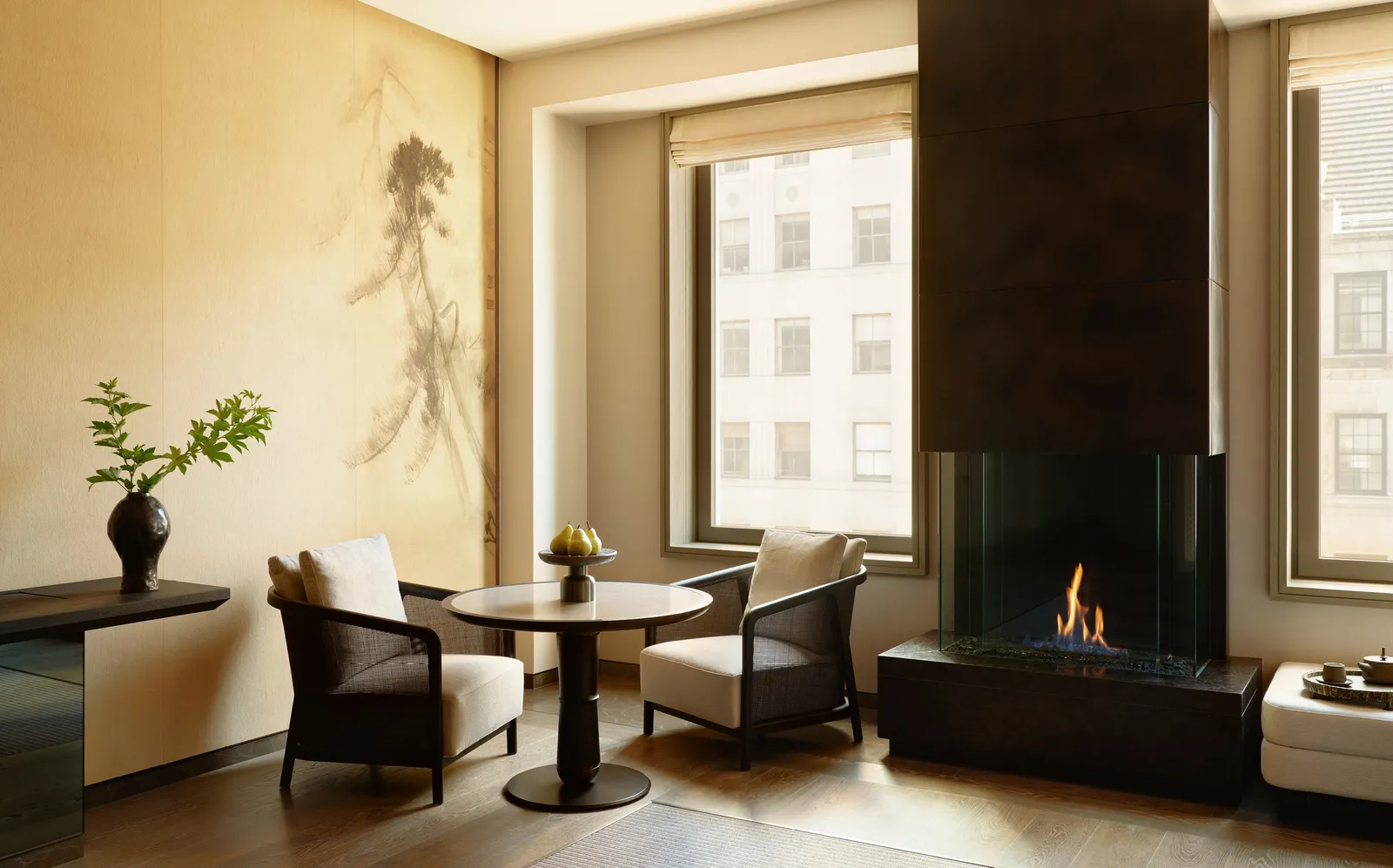 Premier Sanctuary Suite at Aman New York with fireplace, seating area, and floor-to-ceiling windows.