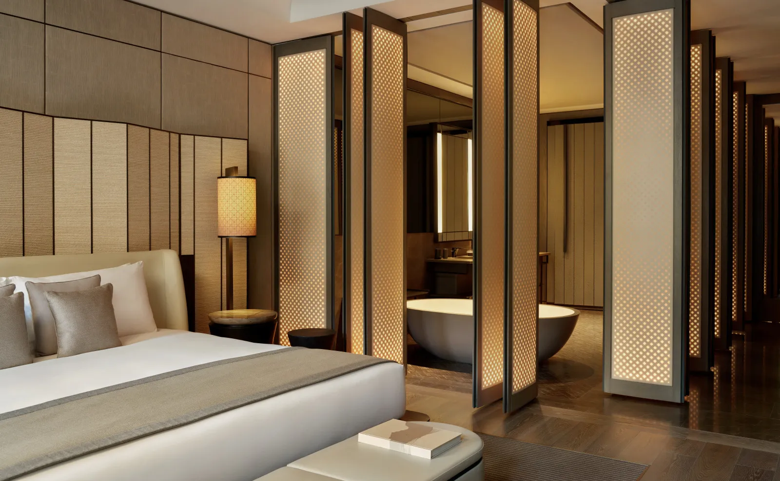 Premier Suite bedroom at Aman New York, featuring a bed with neutral linens and wooden room dividers.