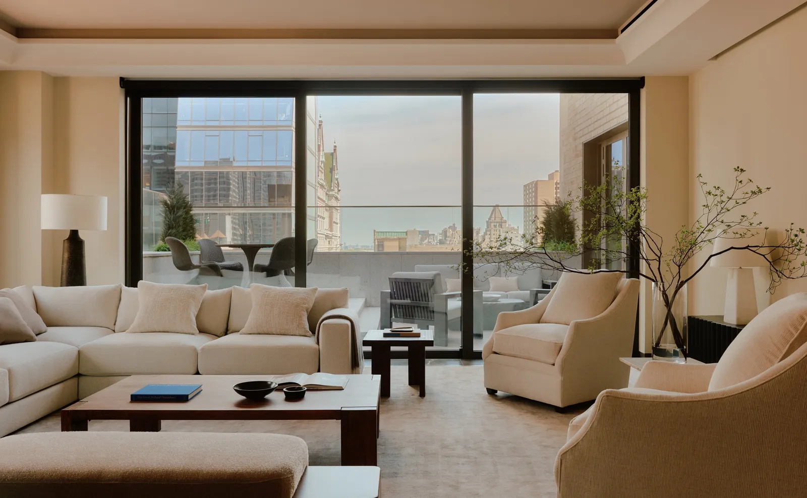 2-bedroom home at Aman New York with living area, seating, and city views through floor-to-ceiling windows.
