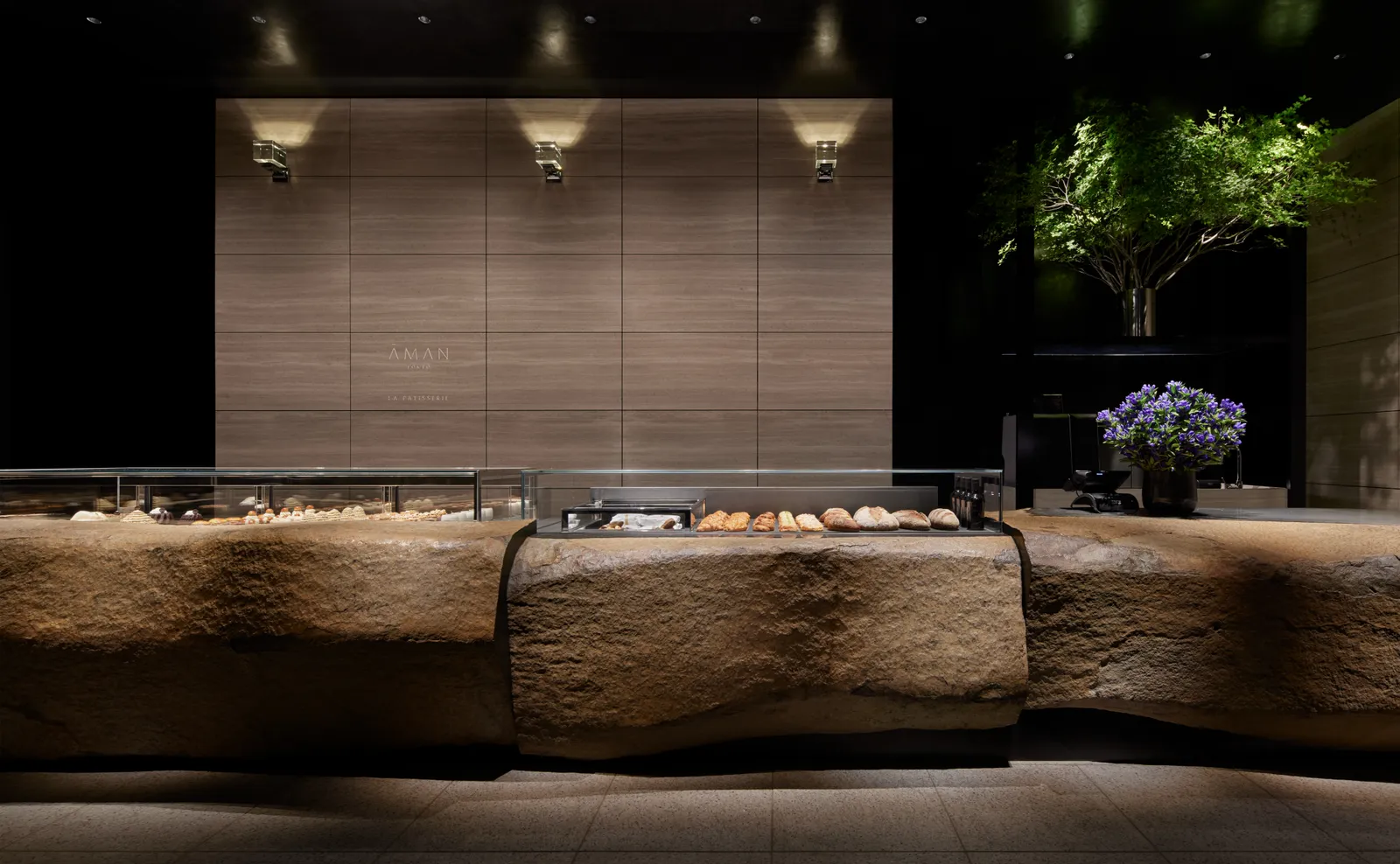 La Pâtisserie on the tower’s B2 floor: the pastry cases set into a long block of rough stone.