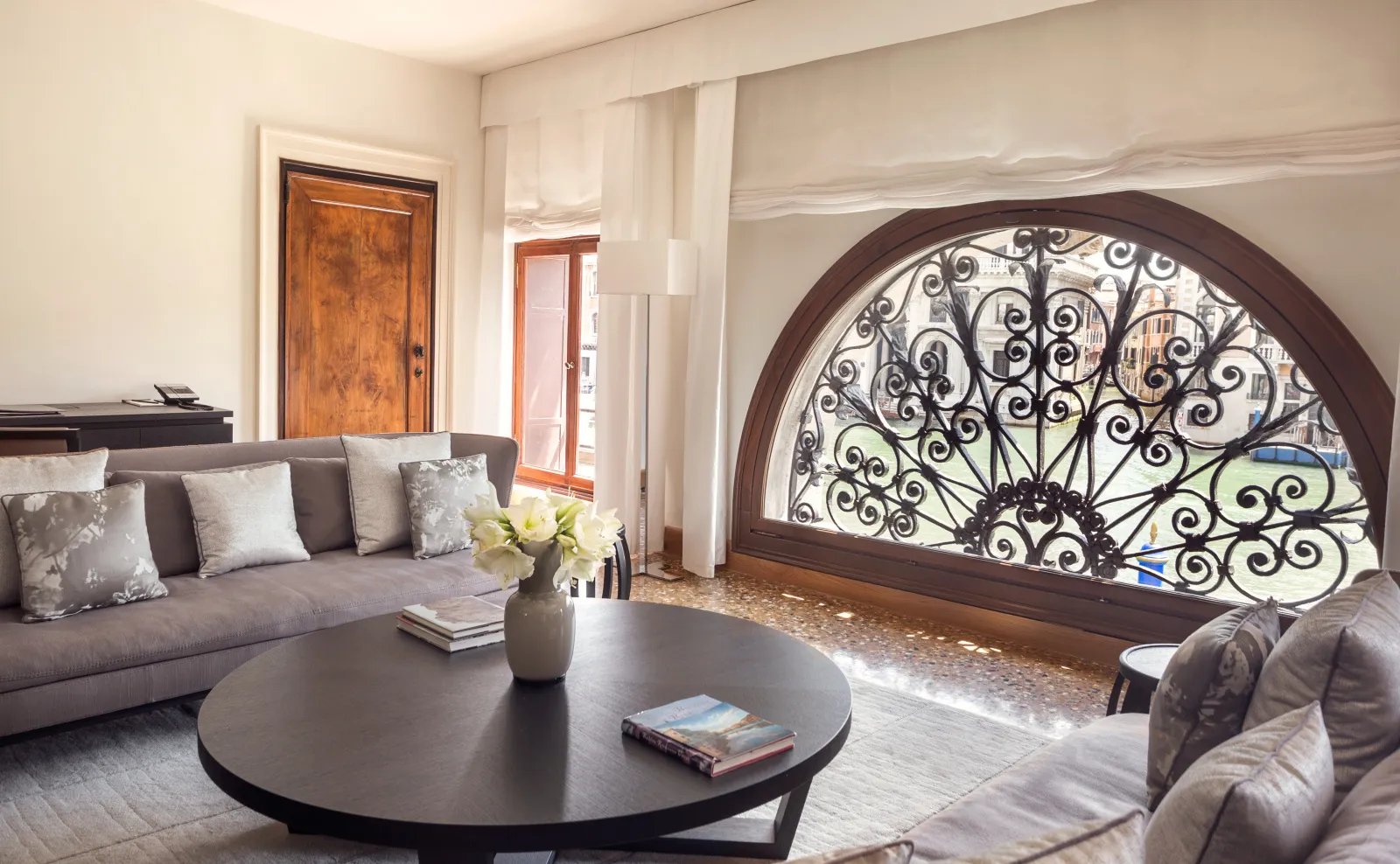 The Grand Canal Apartment sitting room, with the arched window and its wrought-iron grille onto the Grand Canal.